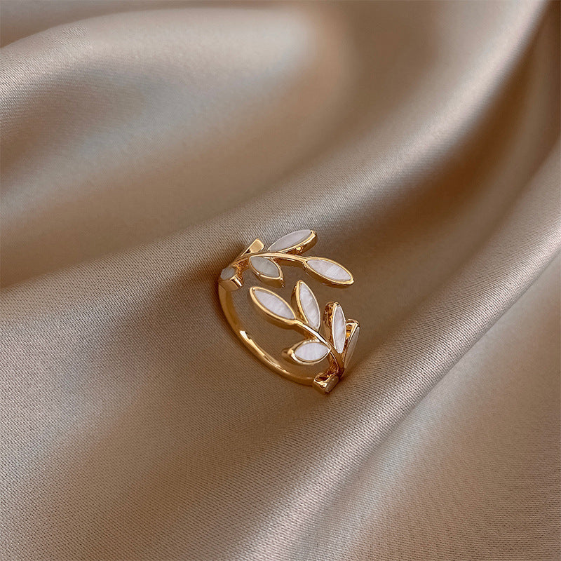 Verstelbare gouden ring met blad en witte opaal
