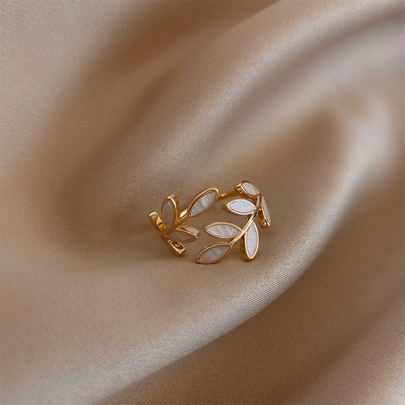 Verstelbare gouden ring met blad en witte opaal